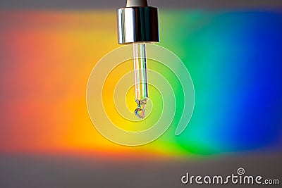 Glass dropper on a prism rainbow background Stock Photo