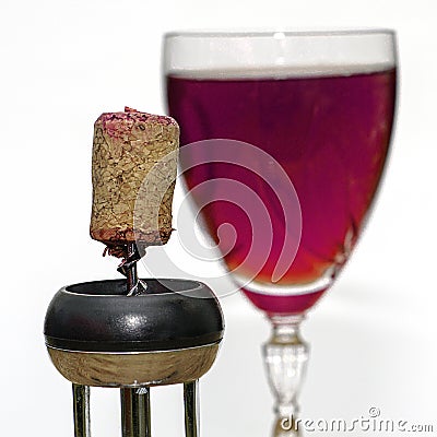 A glass of dry red wine and a wine stopper on a corkscrew close-up Stock Photo