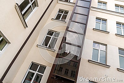 Glass elevator on a multistorey house facade Stock Photo