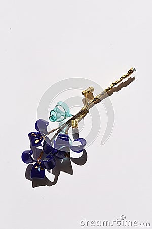 A glass flower twig, three blue flowers with golden stamens Stock Photo