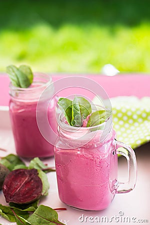 Glass of fresh beetroot juice with bets and leafs . Beetroot smoothie in jar. Pink detox. Stock Photo