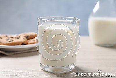 Glass of fresh milk near cookies on white table Stock Photo