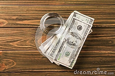 Glass of fresh water with dollar banknotes on wooden table Editorial Stock Photo