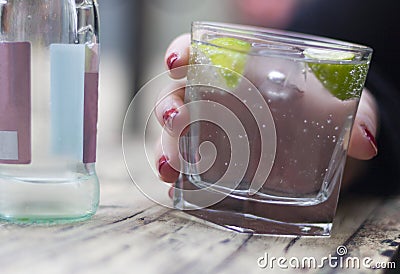 Gin and tonic in womans hand Stock Photo