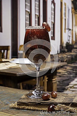 A glass of grape cocktail on a wooden table in a street cafe Stock Photo