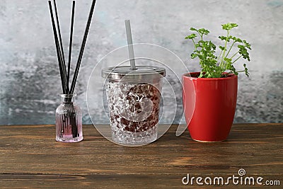 A glass of grape juice and parsley planted in a red flowerpot Stock Photo