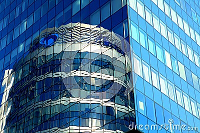 Glass house, high-rise office building, modern skyscraper in which round glass tower is reflected. Tall blue apartment building Stock Photo