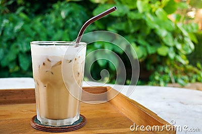Glass iced coffee on wood table green nature background,Iced latte coffee Stock Photo