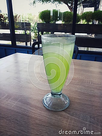 A glass of iced melon lemonade. Fresh orange juice with sweet melon syrup Stock Photo