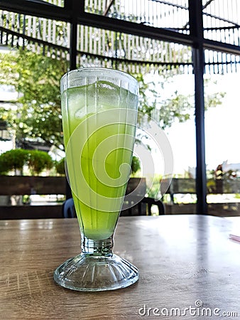 A glass of iced melon lemonade. Fresh orange juice with sweet melon syrup Stock Photo