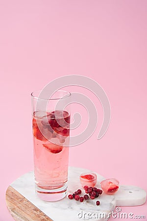A glass of iced tea with frozen strawberry and lingonberry Stock Photo