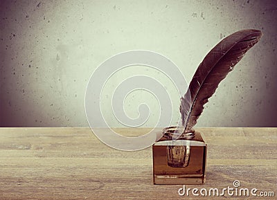 Feather quill pen and glass inkwell on library Stock Photo