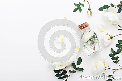 Glass jar with aroma water and white rose flowers for spa and aromatherapy. Top view and flat lay style. Stock Photo