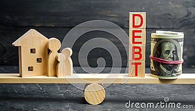 Glass jar with coins and the inscription ` Debt `, family and wooden house. Real estate, home savings, loans market concept. Payme Stock Photo