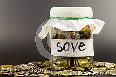 Glass jar with coins and the inscription save Stock Photo