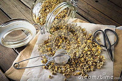 Glass jar with dried chamomile flowers and a tea infuser Stock Photo