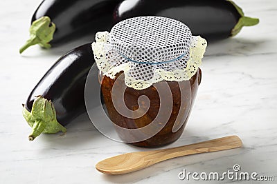 Glass jar with eggplant chutney and fresh eggplanst on the side Stock Photo