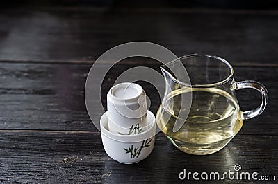 Glass jar of hot tea and set of white ceramic cups Stock Photo