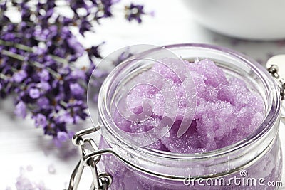 Glass jar of natural sugar scrub and lavender flowers on table, closeup with space for text Stock Photo