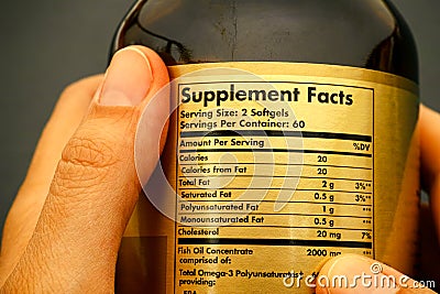 Glass jar with supplement facts in woman hands. Stock Photo