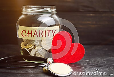 Glass jar with the words Charity and the heart. The concept of accumulating money for donations. Saving. Social medical help from Stock Photo