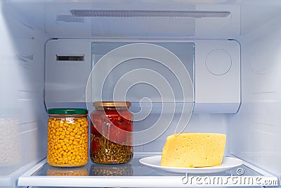 Glass jars of canned products on a fridge shelf Stock Photo