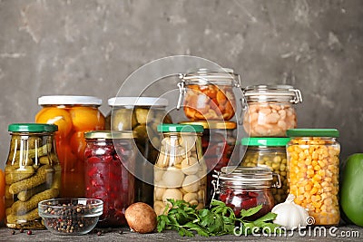 Glass jars with different pickled vegetables on table Stock Photo