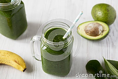 Glass jars full of green smoothie with spinach, avocado and banana, low angle view. Close-up Stock Photo