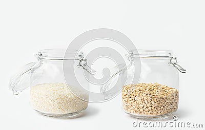 Glass jars with lid filled with dry grains rice oats on white table. Kitchen storage solutions reusable plastic free containers Stock Photo