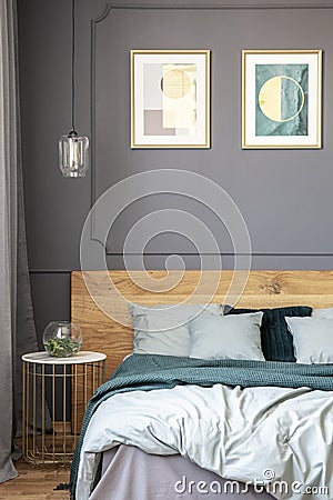 Glass lamp hanging above bedside marble table standing next to w Stock Photo