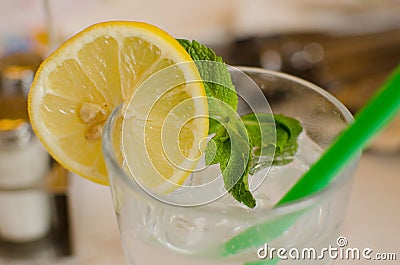 The glass with lemonade, lemon, leaf of mint and ice cubes Stock Photo