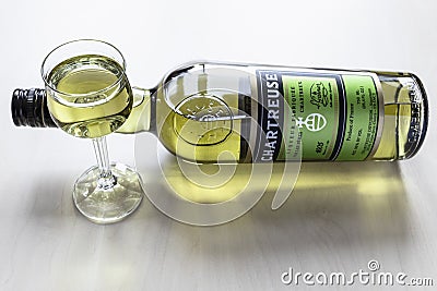 Glass and lying bottle of green Chartreuse liqueur Editorial Stock Photo