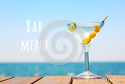 Glass of martini bianco at the wooden pier. Concept of summer vacation. Popular cocktail by the sea.. Bar menu wording Stock Photo
