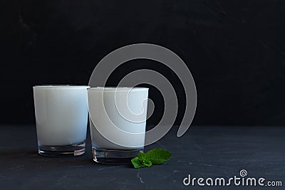 Glass of milk on black background.Lassi drink with fresh green mint on black Stock Photo