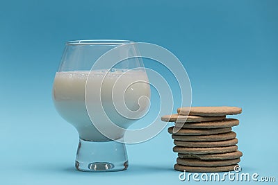 Glass of milk and bunch of cookies on blue background Stock Photo