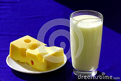 A glass of milk and a piece of cheese Stock Photo