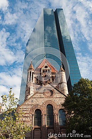 Glass modern skyscraper with ancient church Stock Photo