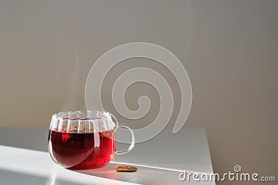 Glass mug with hot black tea on the table. Stock Photo