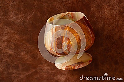 A glass of onyx stone on a colored background close-up Stock Photo