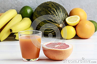 Glass of orange juice and stack of various fruits Stock Photo