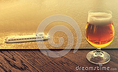 Glass of original Dutch beer on bar desk against Amsterdam waterway at sunset light Stock Photo