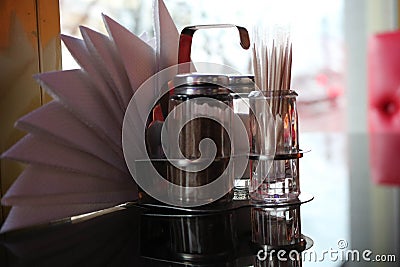 Glass pepper and salt shaker, toothpicks and napkins on the table in the cafe in front of the window Stock Photo