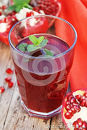 Glass of pomegranate juice and pomegranate fruit on wooden background Stock Photo