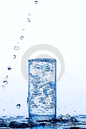 Glass with pouring drinking water Stock Photo