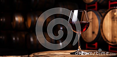 Glass of red wine with a blurred background of cellar, wine-vault with barrels. Generative AI Stock Photo