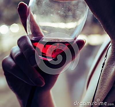 A glass of red wine in the hands of a girl Stock Photo