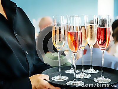 glass of red wine served by a professional caterer on blurred blue grey background Stock Photo