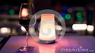 glass of red wine on table of rooftop bar at night Stock Photo