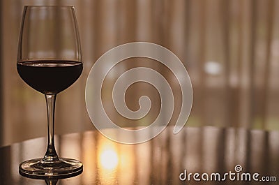 A glass of red wine on table in the room Stock Photo