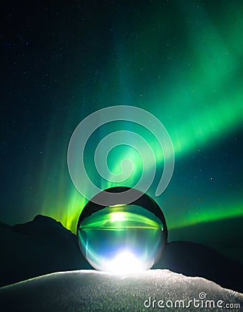 A glass sphere in front of northern light Stock Photo